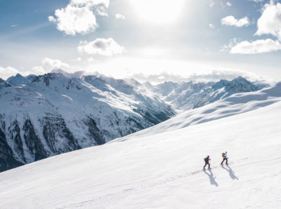 Two people hike up a mountain